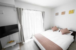 a bedroom with a bed and a large window at Grace Shintoshin in Saitama