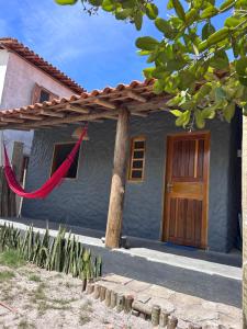 a house with a red hammock in front of it at Casa Mojubá in Porto Seguro