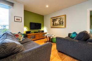 a living room with two couches and a tv at Get Comfy on Frew - CBD Stay near Parklands & Dining in Adelaide