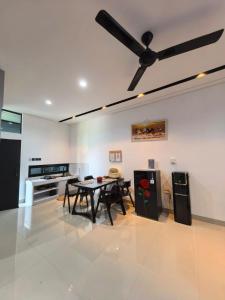 a living room with a table and a ceiling fan at HOMY guesthouse 1 - dekat pintu TOL in Ciperna