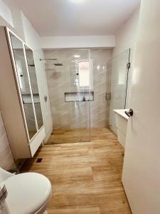 a bathroom with a toilet and a glass shower at Villa Corfus in Barrio El Paraíso +9 photos