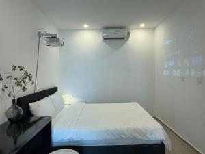 a small room with a bed and a light at The Song - Vitamin Sea & Sun - Căn Hộ Cao Cấp và Sự Lựa Chọn Tốt Nhất in Vung Tau +95 photos
