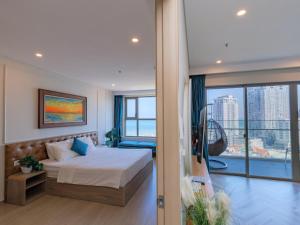 a bedroom with a bed and a large window at The Song - Vitamin Sea & Sun - Căn Hộ Cao Cấp và Sự Lựa Chọn Tốt Nhất in Vung Tau