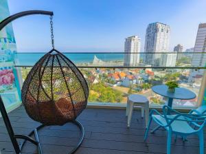 a balcony with a swing and a table and chairs at The Song - Vitamin Sea & Sun - Căn Hộ Cao Cấp và Sự Lựa Chọn Tốt Nhất in Vung Tau