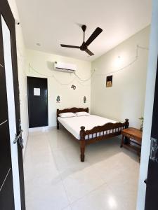 a bedroom with a bed and a ceiling fan at The Last Stop Backpackers Hostel in Auroville +28 photos