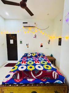 a bedroom with a bed with a colorful comforter at The Last Stop Backpackers Hostel in Auroville