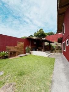 a red building with a patio and a grass yard at Casas 2 Terrace in Laguna