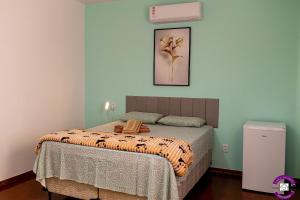 a bedroom with a bed with a blanket on it at Pousada Casa Shanti in Dourados