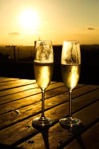 two glasses of wine sitting on a table with the sunset at Casas 2 Terrace in Laguna