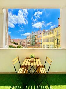 a table and chairs on a balcony with a view of a city at Lisboa Arroios Apartment in Lisbon