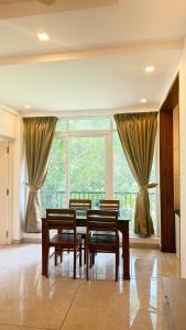 a dining room with a table and chairs and a large window at Orbis Rooms & Apartments in Kakkanad