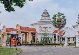a building with a palm tree in front of it at Happy Resort Siem Reap in Phumi Ta Phul