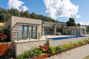 a house with a swimming pool in front of it at Alto Tasmania in Franklin
