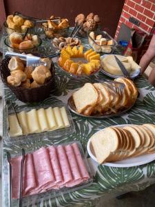 a table full of different types of bread and pastries at Pousada In'capitólio in Capitólio