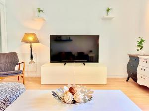 a living room with a tv and a bowl of food at Lisboa Arroios Apartment in Lisbon