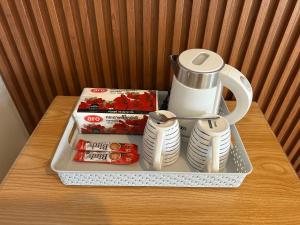 a tray with a tea pot and cups and plates at Baan Smile in Patong Beach