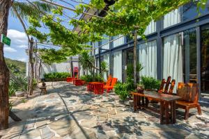 a patio with chairs and tables in a building at Rock Bay by Chành Rành in Vĩnh Hy