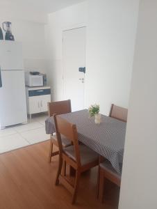 a dining room with a table and chairs and a kitchen at Apartamento próximo arena mrv, expominas e Puc in Belo Horizonte