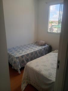 two beds in a room with a window at Apartamento próximo arena mrv, expominas e Puc in Belo Horizonte