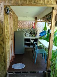 a kitchen with a refrigerator and a table and a chair at Bulkan Villa Rental in General Luna +19 photos