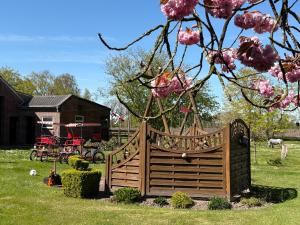 a wooden gate in a yard with a tree at Ferienhaus Franzen 35679 in Uplengen