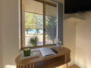 a window in a room with a table with a book at Cosy Bayside Studio in Esperance