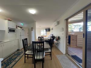 a kitchen and dining room with a table and chairs at Cosy Bayside Studio in Esperance