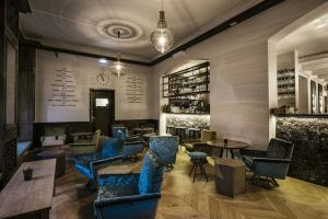 a restaurant with blue chairs and tables in a room at Apótek Hotel Reykjavík by Keahotels in Reykjavík