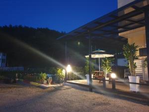 a light shines on a patio with an umbrella at Gosung Shine House in Goseong