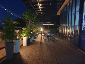 a wooden deck with tables and chairs and potted plants at Gosung Shine House in Goseong