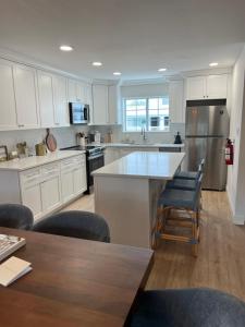 a kitchen with white cabinets and a table and chairs at Oceana By The Sea in Point Pleasant Beach