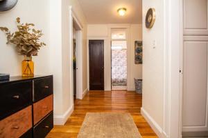 a living room with a dresser and a hallway at Sun-filled Unit, Elevator, Pool, Boston College in Boston