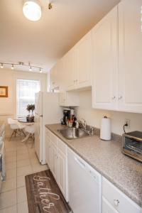 a kitchen with a sink and a white refrigerator at Sun-filled Unit, Elevator, Pool, Boston College in Boston