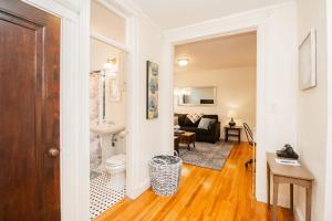 a bathroom with a toilet and a living room at Sun-filled Unit, Elevator, Pool, Boston College in Boston