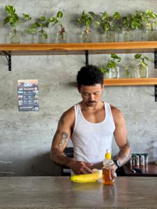 a man standing in a kitchen preparing a banana at Hostal Don Cenobio in Flores