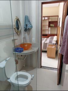 a bathroom with a toilet and a sink and a bed at Suíte mobiliada Duo Mio in Paragominas