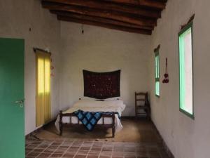 a bedroom with a bed in the corner of a room at Hidden house in La Fronterita de Amaicha in Amaicha del Valle