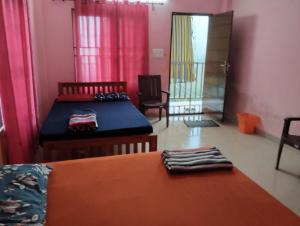 a room with two beds and a table and chairs at Roamwander doublerooms in Vagamon