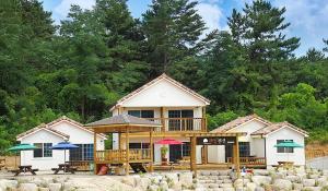 a house with umbrellas in front of it at Samcheok lime pension in Samcheok