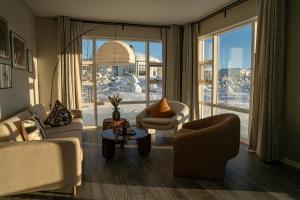 a living room with two chairs and a large window at Hotel Grimsborgir by Keahotels in Ásborgir