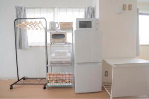 a kitchen with a white refrigerator and a microwave at REKADO ROOM Shinsuizenji 3C in Kumamoto