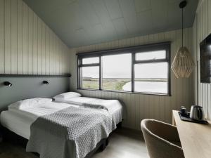 a bedroom with two beds and a window at Hotel Katla by Keahotels in Vík