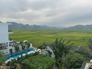 a villa with a pool and a view of a field at Karst Villas Phong Nha in Phong Nha