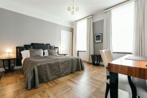 a white bedroom with a bed and a desk at Hotel Borg by Keahotels in Reykjavík
