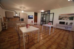 a room with tables and chairs and a kitchen at Villa Colle in Rho