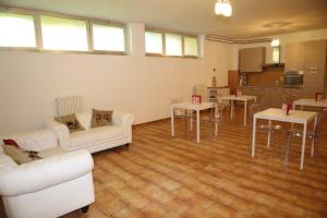 a living room with white couches and a kitchen at Villa Colle in Rho