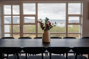 a vase of flowers sitting on a table with chairs at Hotel Grimsborgir by Keahotels in Ásborgir