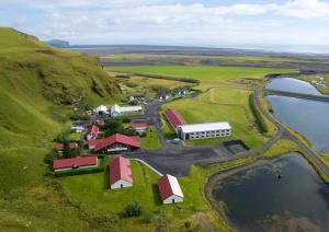 an aerial view of a farm on a hill next to a lake at Hotel Katla by Keahotels in Vík