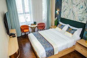 a bedroom with a bed and a table with chairs at Singala Hotel Ulaanbaatar in Ulaanbaatar