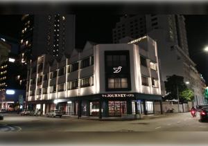 a building with a sign on the front of it at night at The Journey Hotel Penang in George Town